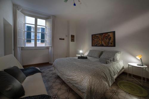 Un dormitorio con una cama grande y una ventana en Oasi nel Cuore di Lucca, super centrale e luminoso, en Lucca