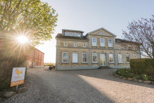 una vecchia casa con un cartello davanti di Büdlfarm - Der Familien-Erlebnishof in Strandnähe a Fehmarn