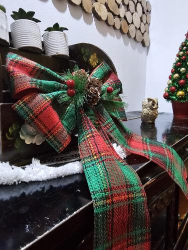 a plaid bow on a table with a christmas tree at Belvedere Resort Moieciu in Moieciu de Jos