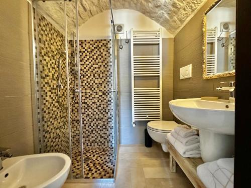 a bathroom with two sinks a toilet and a shower at Savito Guest House in Martina Franca