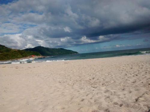 a sandy beach with a view of the ocean at Casas de 1, 2 e 4 quartos-100m da praia- com AC-WIFI-Estac in Camburi