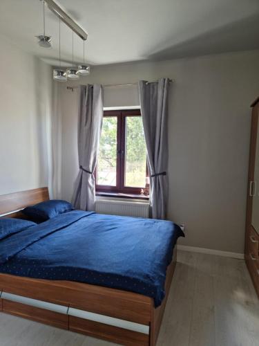 a bedroom with a blue bed and a window at Cosy studio in Bucharest