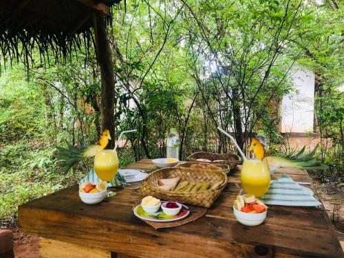 a picnic table with food and orange juice and drinks at Grand freedom in Sigiriya