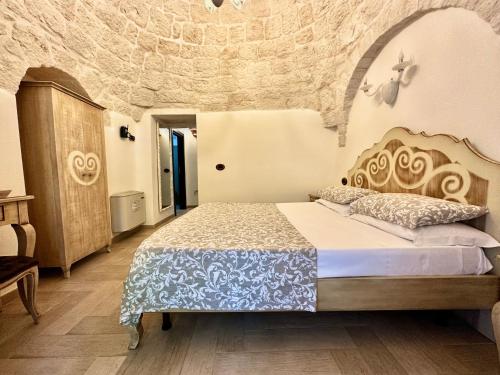 a bedroom with a bed and a stone wall at Savito Guest House in Martina Franca