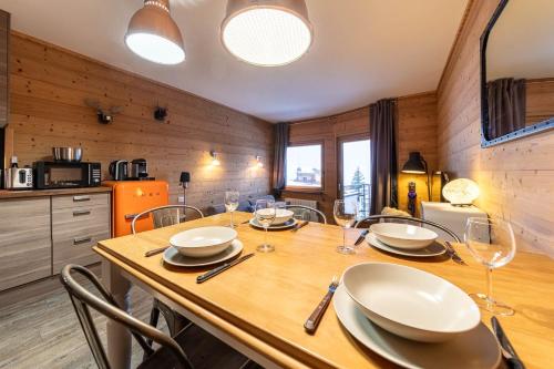 une salle à manger avec une table en bois et des verres à vin dans l'établissement Le Cocooning - IMMODREAMS - Avoriaz, à Avoriaz
