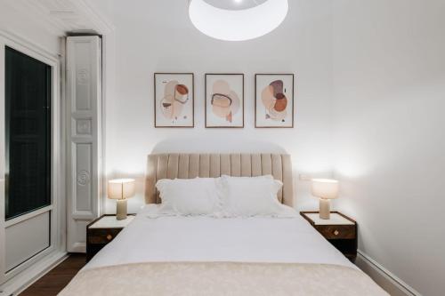 a bedroom with a large white bed with two lamps at Stunning Apartment near Gran Via Metro in Madrid