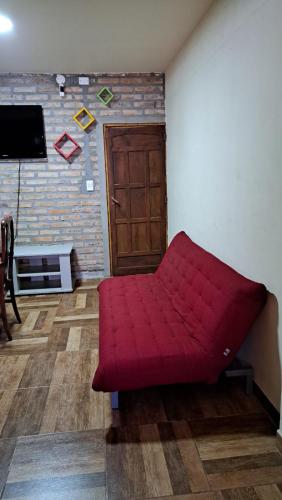 un sofá rojo en una sala de estar con puerta en Guilletemporal en Posadas