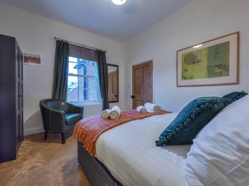 um quarto com uma cama com uma almofada de peixe e uma cadeira em Pass the Keys Charming Victorian Hidden Gem em Market Drayton