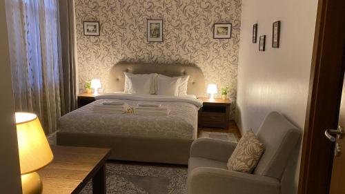 a hotel room with a bed and a chair at Old Town Apartment Ana in Sibiu