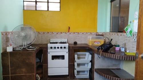 a kitchen with a white stove and a yellow wall at Departamento Familiar Pimentel 04 - Ica centro in Ica