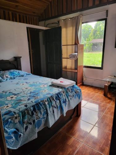 1 dormitorio con cama y ventana grande en Hospedaje las brisas, en Puerto Jiménez