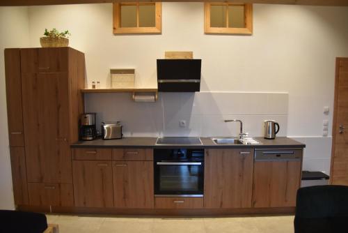 a kitchen with a sink and a stove at Ferienwohnung beim Hainz in Dietramszell
