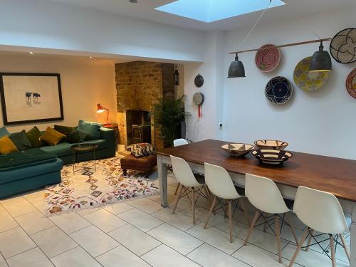 uma sala de estar com uma mesa e um sofá verde em Beautiful London Victorian house, sleeps 12 em Londres