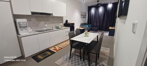 een kleine keuken met een tafel en stoelen in een kamer bij D' Residensy Homestay in Kuala Lumpur