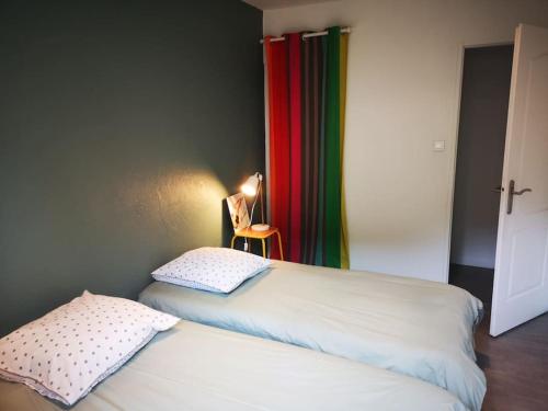 - une chambre avec 2 lits, une lampe et des rideaux dans l'établissement Au goût du miel. Luberon-Provence., à Maubec