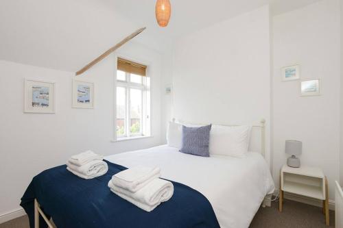 a bedroom with a bed with towels on it at The Dagmar Grove Apartments in Nottingham