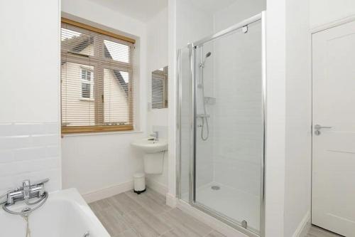 a white bathroom with a shower and a sink at The Dagmar Grove Apartments in Nottingham