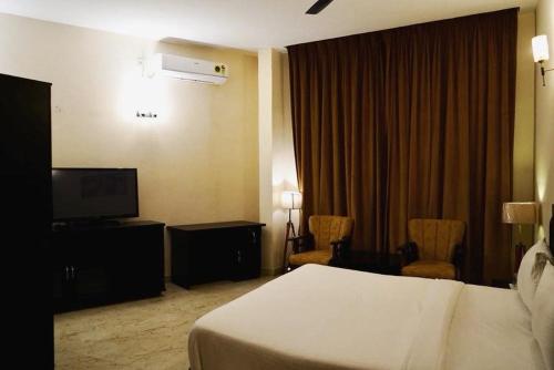 una camera d'albergo con letto e TV di Hotel Saluja Primeland a Parāsia