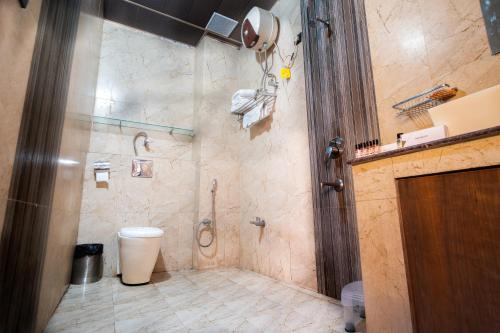 a bathroom with a toilet and a shower at Chanakya Resort in Rishīkesh