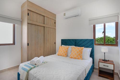 a bedroom with a bed with two towels on it at Apartamento vista a piscina, gym y cerca de playa in Punta Cana