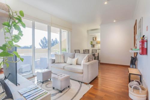a living room with a couch and a large window at Blue Sky in Funchal
