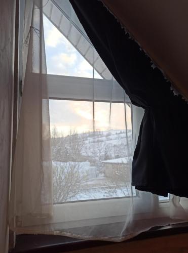 a window with a view of a snow covered field at Apartaments Gory in Niedzica Zamek