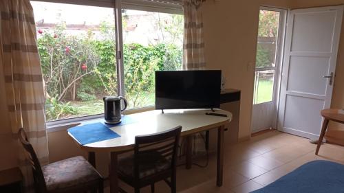 Habitación con escritorio, TV y ventana. en Lo de Tini en Gualeguaychú