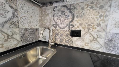 a kitchen with a stainless steel sink and wallpaper at Alloggio sul parco in Modena