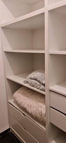 a closet with white shelves and a bed at Studio at the Kibbutz in Ashdot Ya‘aqov