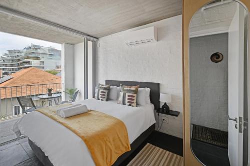 een slaapkamer met een groot bed en een balkon bij Modern Living Mountain&ocean View 100m To Beach in Kaapstad