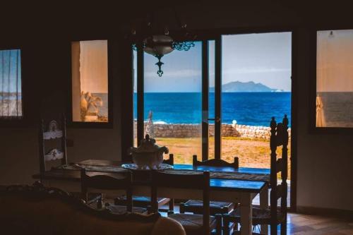 uma sala de jantar com uma mesa e vista para o oceano em Dar el haouaria em El Haouaria