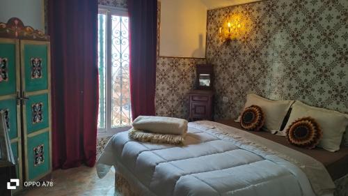 um quarto com uma cama grande e uma janela em Dar el haouaria em El Haouaria