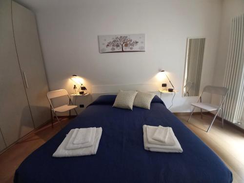 een slaapkamer met een blauw bed met 2 handdoeken erop bij PARADISE in Sale Marasino