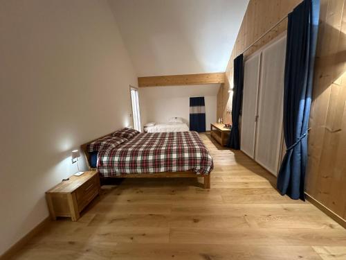 a bedroom with a bed and a wooden floor at Nido di Laura in Santa Maria Maggiore