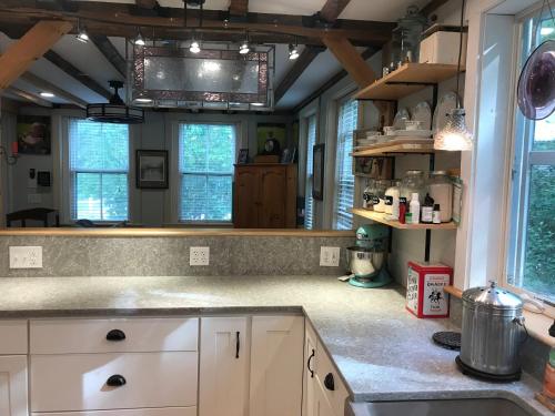 a large kitchen with white cabinets and windows at Cozy 1882 renovated cape in Plainfield