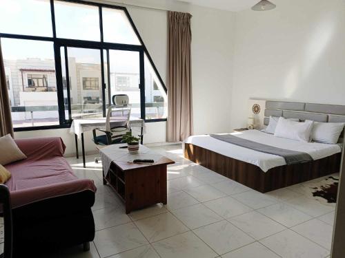 Jumeirah Beach Villa في دبي: غرفه فندقيه بسرير واريكه