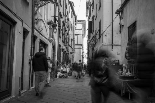 a group of people walking down a narrow street at Nido sui tetti di Lucca, romantico e centralissimo in Lucca