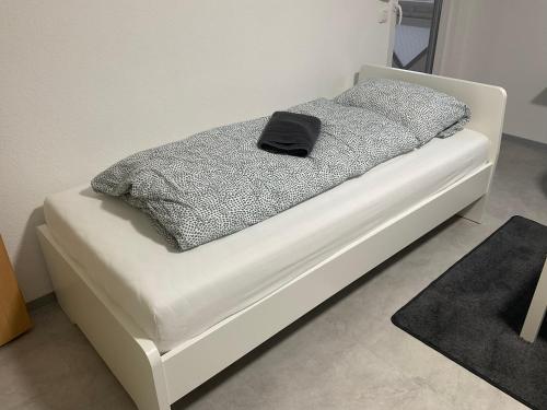 Una cama blanca con una almohada negra. en Zentrum Kassel 2 en Kassel