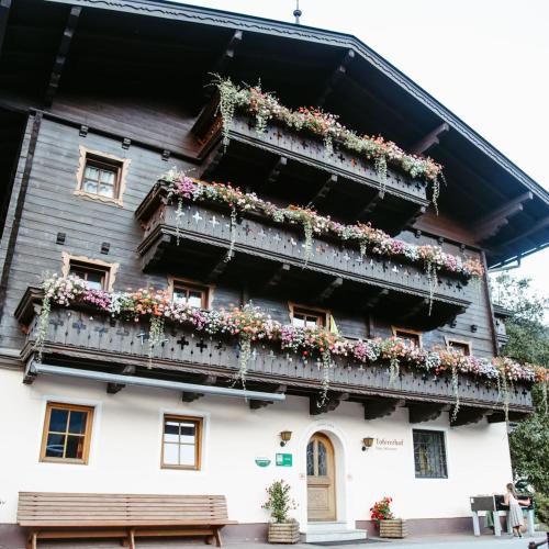 een oud huis met bloemen op de balkons bij Tofererhof in Bad Hofgastein