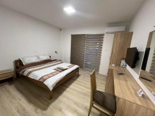 1 dormitorio con 1 cama y TV de pantalla plana en Royal Stars Apartments, en Strumica