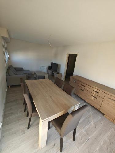 une salle à manger avec une table et des chaises en bois dans l'établissement Chambre Poitiers, à Poitiers