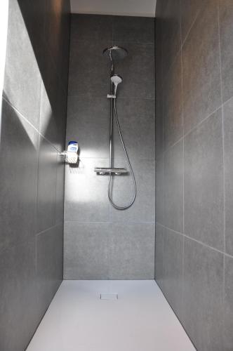 a shower with a shower head in a bathroom at Gîte de Lombard 2 in Ieper