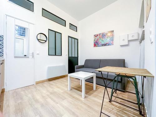 un salon avec un canapé et une table dans l'établissement Marais - Canal st Martin 20m2, à Paris