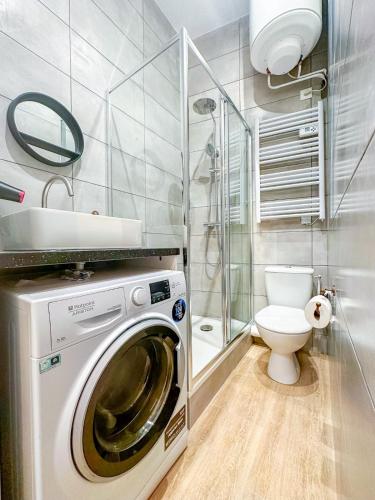 une salle de bain avec machine à laver et toilettes dans l'établissement Marais - Canal st Martin 20m2, à Paris