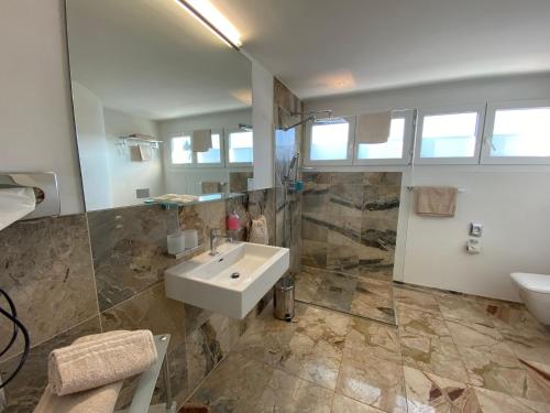 een grote badkamer met een wastafel en een toilet bij Businesshotel Lux in Luzern