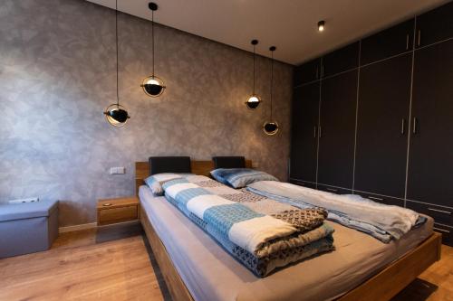 a bedroom with a large bed and some lights at Ruhiges & luxuriöses Business Apartment im Zentrum in Chemnitz