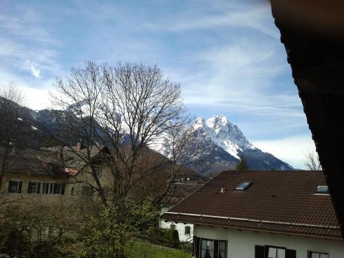 Cette maison offre une vue sur une montagne enneigée. dans l'établissement Gästehaus Bader, à Garmisch-Partenkirchen
