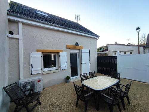 a patio with a table and chairs and a building at Gîte Le Clos Controis in Contres