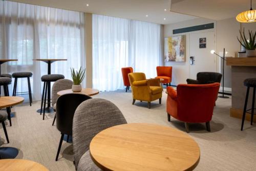 a waiting room with chairs and tables and chairs at Best Western Auray le Loch in Auray