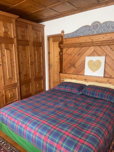 a bedroom with a bed with a checkered blanket at Bike and Ski dreams in Cortina dʼAmpezzo